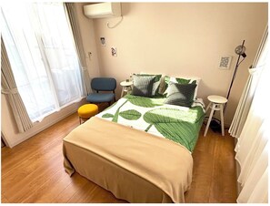 Bedroom with seating area, desk and terrace access. Queen Bed.