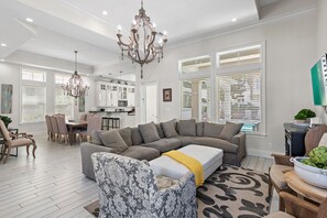 Large, Open Living Space with vaulted ceilings and plenty of comfortable seating around a 65" Smart TV overlooking the your very own backyard Oasis!
