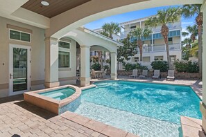 Stunning private pool and hot tub, perfect for relaxing after a day at the beach. Lounge in the sun with palm trees and peaceful surroundings, offering a true escape right outside your door.