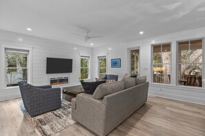 Living room opens to a screened porch with outside dining for six