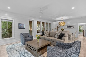 Living room opens to a screened porch with outside dining for six