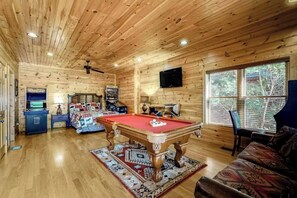 Unwind in this beautiful mountain cabin with stunning views and non-stop fun! Pool table, arcades, cozy beds, and the perfect log cabin vibe.