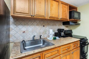 Kitchen with stove, microwave, and ample cabinet storage.