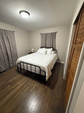 Queen bed, bedside table with built in outlet. This bedroom also includes a TV. 