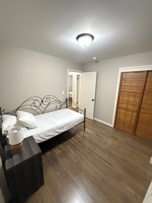 Twin bedroom and bedside table with outlets and a lamp.