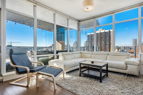 A spacious living room with floor-to-ceiling windows, filling the space with natural light and offering stunning views.