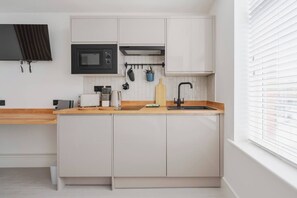 Kitchenette inside the studio for privacy and comfort. The only difference from the shared full kitchen is that it does not have an oven, but you can still cook on the electric hob. Also includes mini fridge, washer, microwave and toaster.