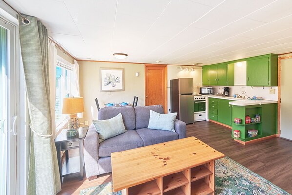 Bright and cozy living room with a comfy sofa and simple wooden table—perfect for unwinding.