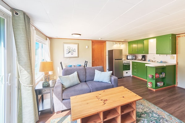 Bright and cozy living room with a comfy sofa and simple wooden table—perfect for unwinding.