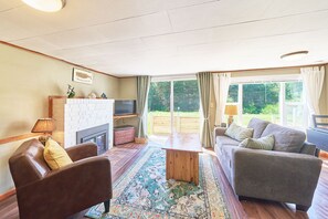 Bright living room with a cozy sofa, wood table, and electric fireplace.