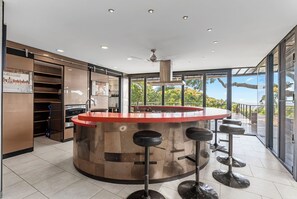 Chef’s dream kitchen featuring a bold red island with seating for 12 and high-end stainless steel appliances.