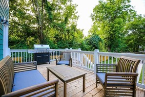 Wooded views with cozy seating and a full grill setup.