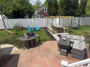 Backyard area with pergola and lots of lawn furniture