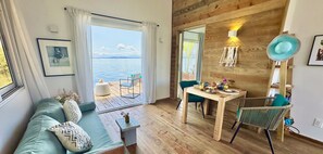The cozy living room with sofa and dining table and an amazing ocean view