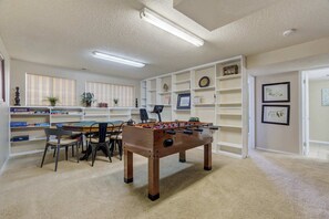 Game room and library in one! Enjoy a competitive foosball match or unwind with a good book in this spacious and inviting entertainment area.

