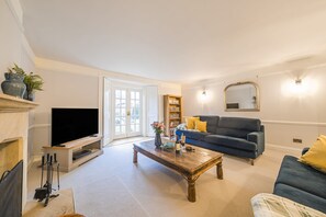 Beech House, Evershot: The spacious sitting room with original shutters and french doors to the garden