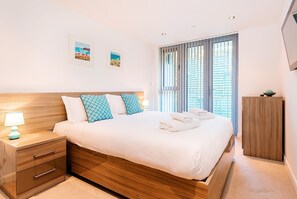 11 Zinc, Newquay: Bedroom one with a sumptuous 5' king-size bed, wall-mounted television and en-suite shower-room