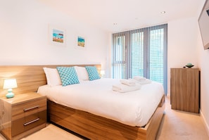 11 Zinc, Newquay: Bedroom one with a sumptuous 5' king-size bed, wall-mounted television and en-suite shower-room