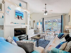 - Breezy coastal living room with plush seating, seaside décor, and cheerful charm
- Large glass doors lead to the patio, filling the space with natural Florida sunshine
- Relax, stream your favorite shows, or dine together in this open concept oasis