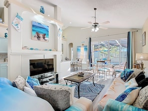 - Breezy coastal living room with plush seating, seaside décor, and cheerful charm
- Large glass doors lead to the patio, filling the space with natural Florida sunshine
- Relax, stream your favorite shows, or dine together in this open concept oasis