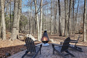 Cozy up by the fire! 🔥🌲 Nestled in a serene wooded setting, this outdoor firepit area is perfect for unwinding after a day of adventure. Grab a seat, roast marshmallows, and enjoy the peaceful nature views!
