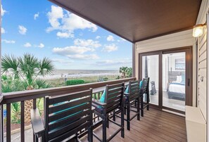 Cozy balcony with high chairs, wooden railing, and breathtaking views.