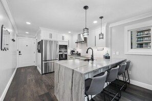 Gather around the kitchen island with gorgeous waterfall edge.