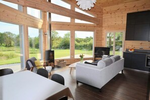 Table, chairs, sofa, windows out to view of the garden