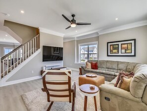 Comfortable and airy living room with plush seating, a ceiling fan, and an inviting layout perfect for relaxation.