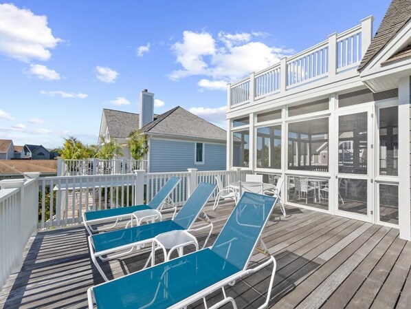 Sun-soaked deck with comfortable lounge chairs, ideal for relaxing under the sky.