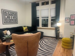 Living area with a large Plush sofa, arcade game & high ceilings