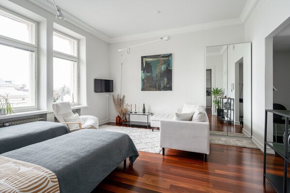 The living room features a spacious living area with high ceilings and large windows, creating a sense of openness.