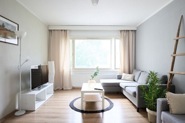 Bright and cozy living room with two comfortable sofas – perfect for relaxing after a long day. The space features a flat-screen TV and fresh, modern decor.