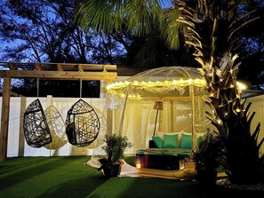 Outdoor daybed with seasonal glamping tent and two adult swings