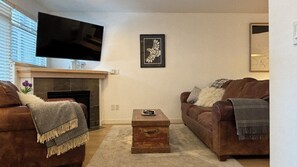Living room with large tv over the gas fireplace.