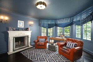 Cozy room with a warm fireplace and two plush single sofas, perfect for relaxation.