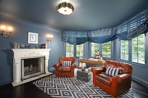 Cozy room with a warm fireplace and two plush single sofas, perfect for relaxation.