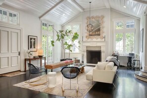 Elegant and spacious living room featuring a large TV, cozy fireplace, premium sound system, and a comfortable sofa