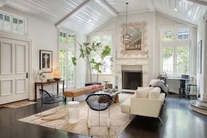 Elegant and spacious living room featuring a large TV, cozy fireplace, premium sound system, and a comfortable sofa