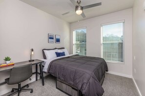 Cozy and comfortable bedroom with a plush bed, soft linens, an en-suite bathroom, and plenty of natural light—plus a dedicated workspace for remote work or study!