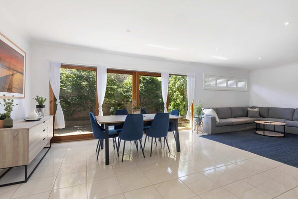 The dining table provides room for shared family meals, complemented by a breakfast bar and outdoor dining table