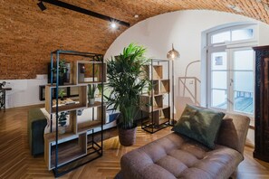 "Peaceful reading nook with chaise lounge, elegant shelving unit, and natural light from the French windows.