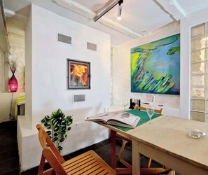 Fireplace, chairs, table, and art.