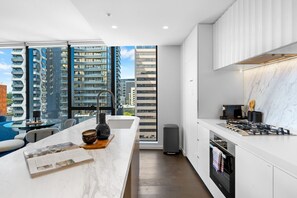 This side features a fully functional kitchen, featuring a spacious countertop and a view of the city buildings and urban living.