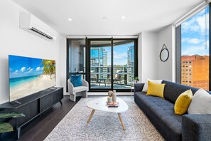 Spacious living room with a city view, featuring modern entertainment for a relaxing stay.