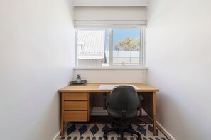 Stay productive in your home office, featuring a sleek wooden desk, ergonomic chair, and natural light—perfect for remote work or study sessions.