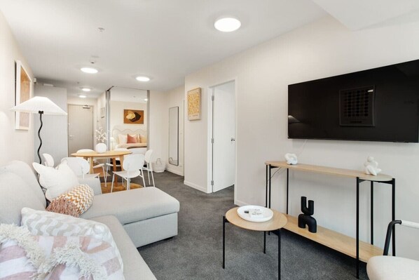 The open-plan living, dining and kitchen areas are filled with light from the windows.