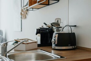 Toaster, coffee machine, and kettle are ready for you. Coffee pods and a variety of teas are also provided.