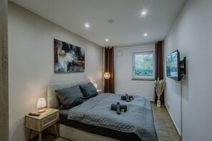 A view into the second bedroom with double bed and flatscreen TV