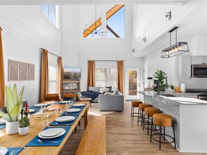 Open-concept cabin with a cozy fireplace, modern kitchen, and spacious dining area.